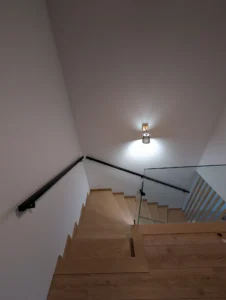 Nowoczesna balustrada szklana schodowa z czarnym pochwytem ściennym – bezpieczne szklane barierki i drewniane stopnie Loft Steel Tarnów