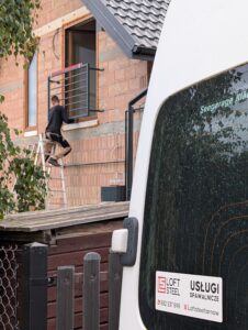 Ekipa Loft Steel podczas montażu czarnej balustrady francuskiej na nowym budynku – profesjonalne usługi spawalnicze i montażowe Tarnów