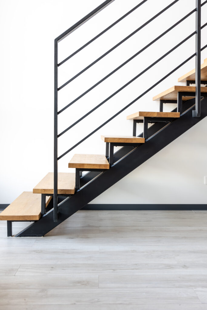 Nowoczesne schody o konstrukcji stalowej z drewnianymi stopniami – czarna balustrada z profilami poziomymi Loft Steel Tarnów