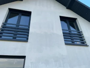 Dwie nowoczesne balustrady francuskie na elewacji domu – czarne stalowe portfenetry z poziomymi profilami Loft Steel Tarnów