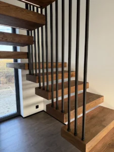 Nowoczesne drewniane schody półkowe z czarną stalową balustradą pionową – lamelowe barierki od stopnia do sufitu Loft Steel Tarnów
